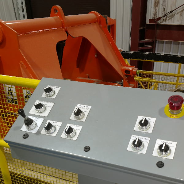 Industrial controls button station with machine in background